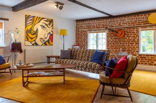 a living room with a couch and a brick wall at 1960s Inspired City Centre Apartment for 4 with Parking in Norwich