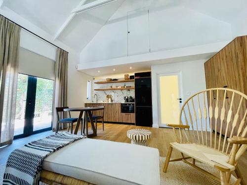 a bedroom with a bed and a dining room at Mountain Cottages at Haskell Vineyard in Stellenbosch
