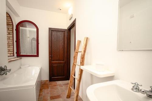 uma casa de banho com um lavatório, uma banheira e um espelho. em Tenuta Pianirossi em Cinigiano