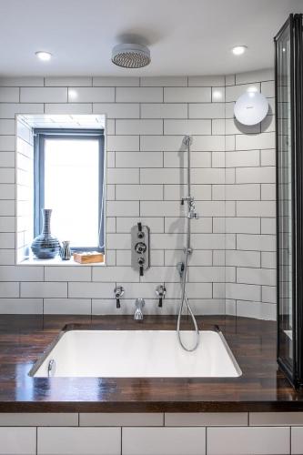 a bath tub with a shower in a bathroom at 1960s Inspired City Centre Apartment for 4 with Parking in Norwich