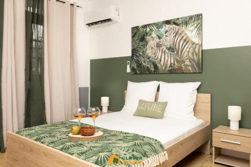 a bedroom with a bed with two glasses of wine at Le Lodge Safari au centre-ville in Cayenne