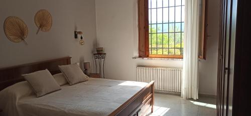 appartamento aroma في Radicondoli: غرفة نوم بسرير كبير مع نافذة