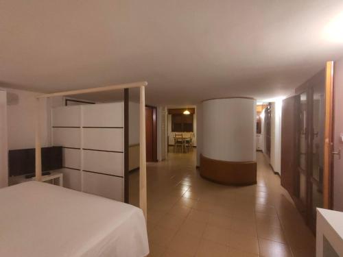 ein Hotelzimmer mit einem Bett und einem Flur in der Unterkunft Monteforte Home - Ruggero in Catania