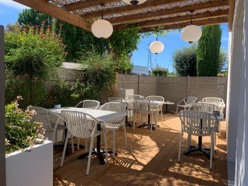 a patio with tables and chairs under a pergola at Kyriad Montpellier Ouest St Jean de Védas - A709 in Saint-Jean-de-Védas