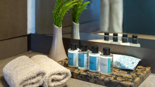 a group of five shampoo bottles on a counter in a bathroom at Mövenpick Hotel Gammarth Tunis in Gammarth