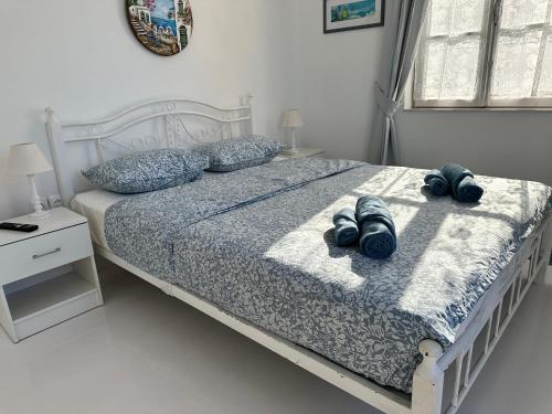 a bedroom with a bed with two pairs of shoes on it at Louisa’s View in Hydra