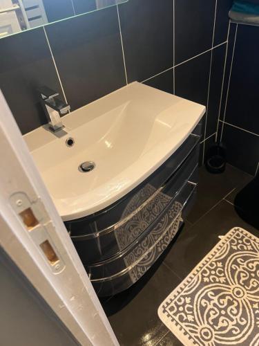 ストラスブールにあるle couventのタイル張りの壁、白い洗面台付きのバスルーム