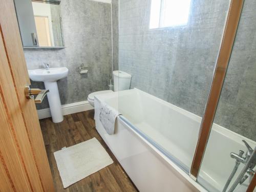 a bathroom with a bath tub and a sink at 8 New Houses in Wrexham