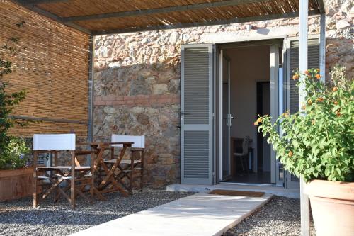 a patio with a table and chairs in front of a building at Bio Agriturismo Corte degli Ulivi in Grosseto