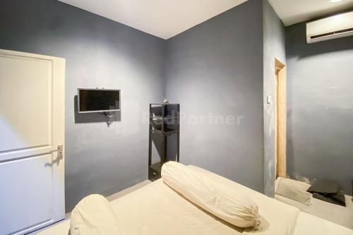 una camera con letto e TV a parete di Mandala Residence RedPartner a Pulauberayan Dadap