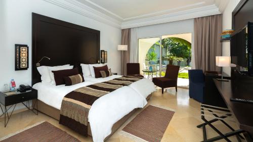 a bedroom with a large bed and a television at Mövenpick Hotel Gammarth Tunis in Gammarth