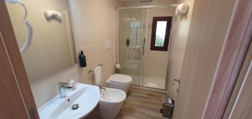 a bathroom with a sink and a toilet and a shower at Hotel Mon Repos in Baja Sardinia