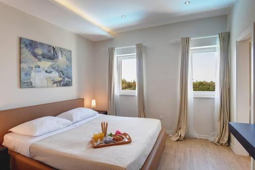 Un dormitorio con una cama con una bandeja de comida. en Villa Rahela by Istrialux, en Štokovci