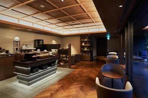 a lobby with a salon with a counter and chairs at Atami Izusan Karaku in Atami