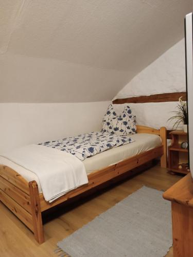 una cama de madera con almohadas azules y blancas. en Erlebnisreiterhof Wolferstadt, 