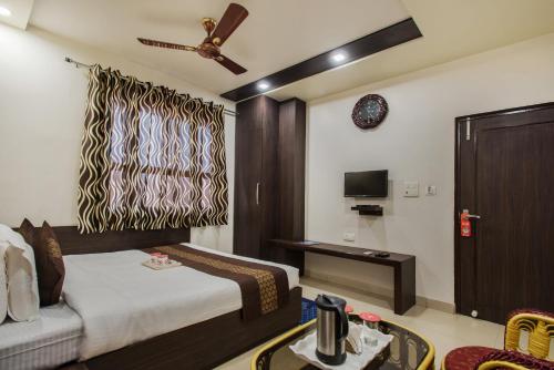 um quarto de hotel com uma cama e uma televisão em Hotel Joy em Jaipur