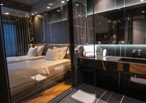 Zimmer mit einem Bett und einer Glaswand in der Unterkunft Arka Art Hotel in Tirana