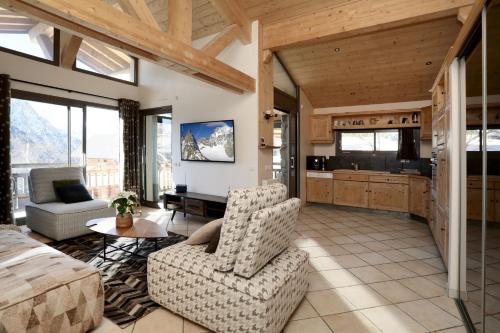 ein Wohnzimmer mit einem Sofa, Stühlen und einem TV in der Unterkunft Swan 3 - Appartement 6 couchages in Les Deux Alpes