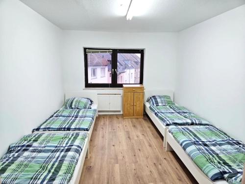 2 camas en una habitación con ventana en Work & Stay Leverkusen en Leverkusen