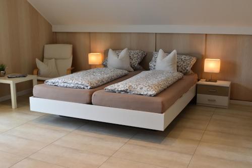 a bedroom with a large bed with two lamps on it at Ferienwohnung (H)Auszeit Pape in Winterberg