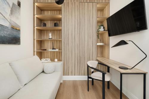 a living room with a white couch and a desk at WAVEVIEW PREMIUM 10th Floor Baltic View in Międzyzdroje