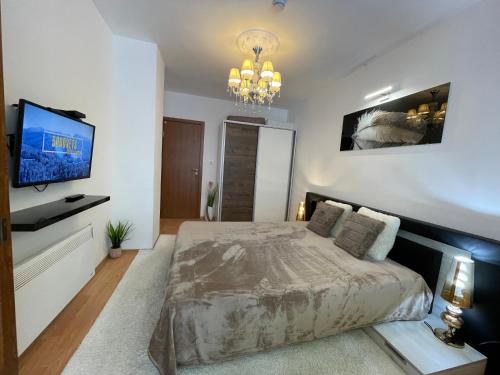 a bedroom with a bed and a flat screen tv at Luxury Apartament in "Sequoia" 2 in Borovets