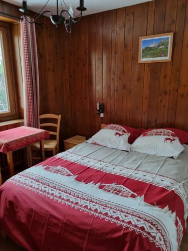 a bedroom with a large bed in a room with wooden walls at Stellina in Lanslevillard