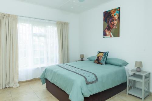 1 dormitorio con cama y ventana grande en The Cottages @ Ezulwini, en Lobamba