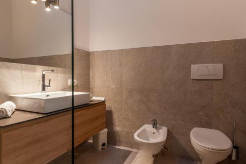 a bathroom with a sink and a toilet and a sink at Funtnatsch Apartment Langkofel in Laion