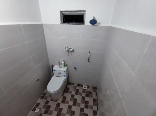 ein kleines Bad mit einem WC und einem Fenster in der Unterkunft Homestay Schemumarc in Arau