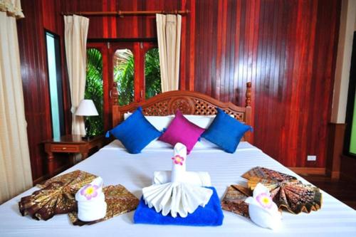 una camera da letto con un letto bianco con cuscini colorati di Haad Yao Bayview Hotel a Ko Phangan