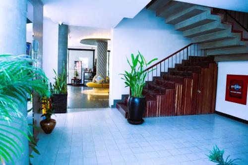 a hallway with a staircase and plants in a building at Siem Reap Palace Hotel & Spa in Siem Reap