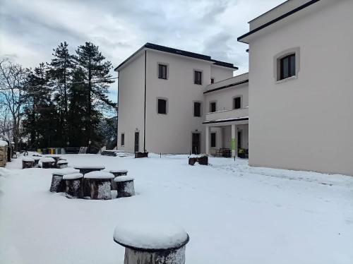 a building with snow on the ground in front of it at Ostello Ossigeno in Campodimele