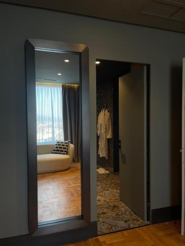 a mirror in front of a living room with a couch at Arka Art Hotel in Tirana