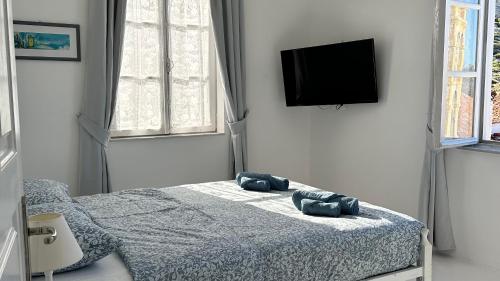 a bedroom with a bed with two blue pillows on it at Louisa’s View in Hydra
