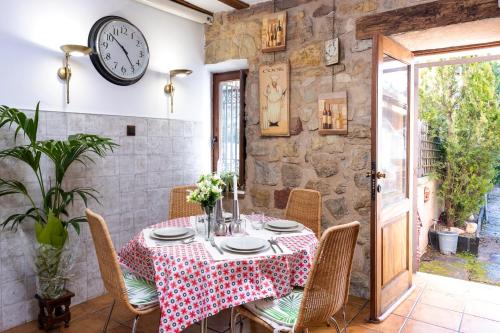 a dining room with a table and a clock on the wall at Abad casa Siguenza 250m2 vivienda y exterior in Sigüenza