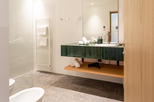 a bathroom with a sink and a mirror at Granpanorama Hotel StephansHof in Villandro