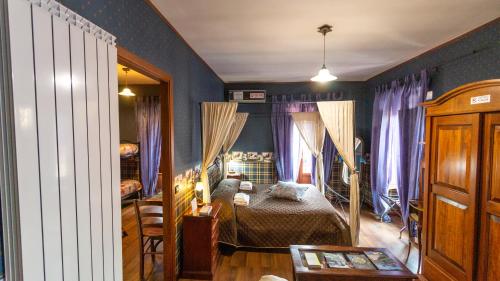 Schlafzimmer mit einem Bett mit blauen Wänden und lila Vorhängen in der Unterkunft Portella delle Fate in Sora