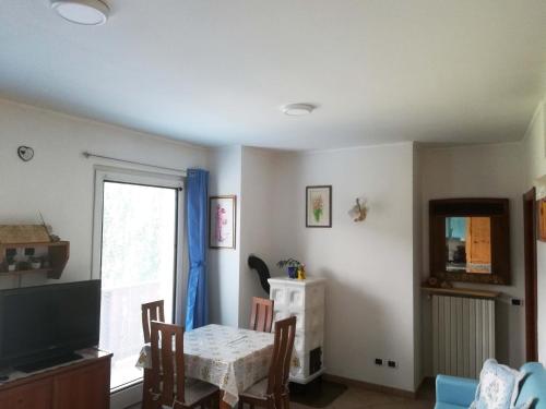 a dining room with a table and a television at Appartamenti Codàn in San Vito di Cadore