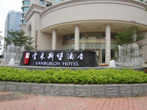 un edificio con una señal delante de él en Vanburgh Hotel - Free shuttle bus transfer during Canton Fair, en Guangzhou