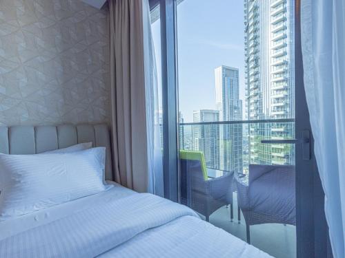 a bedroom with a bed and a window with a view at MH- Act - Burj View 3BHK-REF4008 in Dubai