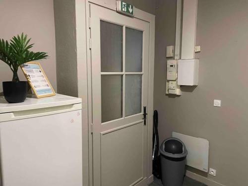 une porte dans une salle d'hôpital avec une plante en pot dans l'établissement La Suite de l’Empereur/ Logement neuf janvier 2024, à Orléans