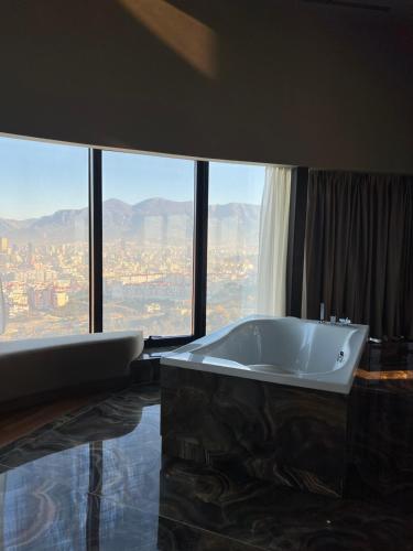 a bathroom with a tub and a large window at Arka Art Hotel in Tirana