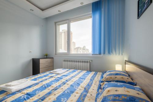 a bedroom with a bed and a large window at Lovely 2 BDR suite next to Mall of Sofia in Sofia