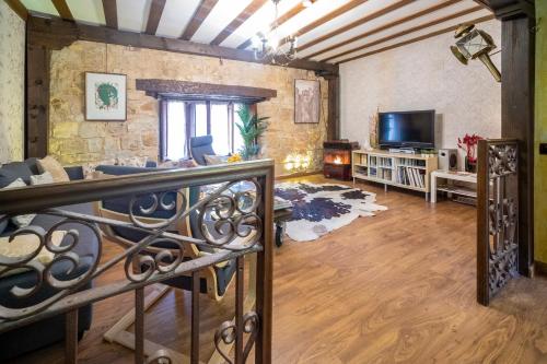 a living room with a couch and a tv at Abad casa Siguenza 250m2 vivienda y exterior in Sigüenza