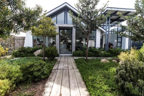 a house with a wooden walkway in front of it at Leisure Isle 2 bedroom home with essential power. in Knysna