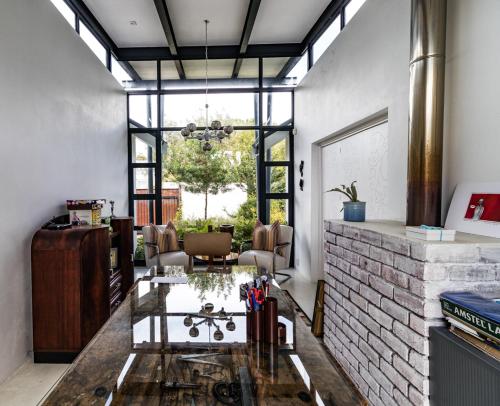 a living room with a glass table and a brick fireplace at Leisure Isle 2 bedroom home with essential power. in Knysna