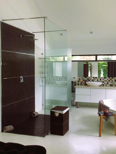 a bathroom with a glass shower stall and a sink at Leisure Isle 2 bedroom home with essential power. in Knysna