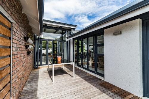 an outdoor deck with glass doors and a table at Leisure Isle 2 bedroom home with essential power. in Knysna