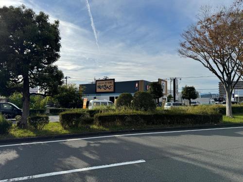 a building with a sign on the side of a road at MR TOMO FUJI in Fuji